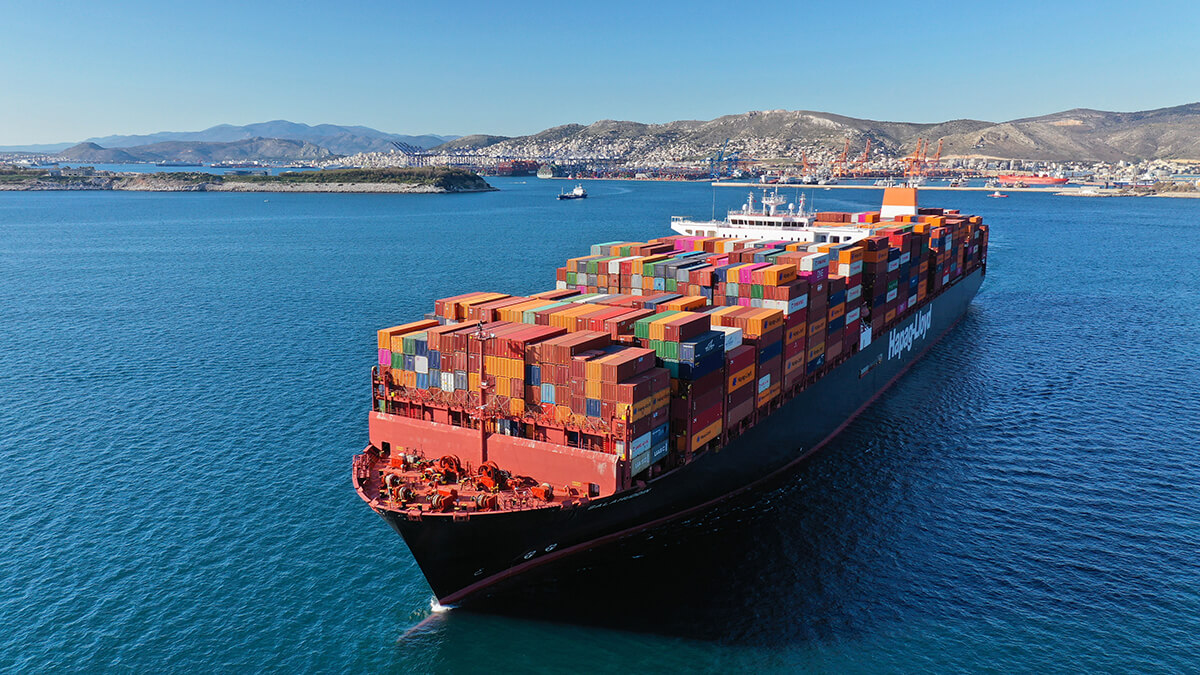 Aerial drone photo of huge container ship leaving logistics and container terminal of Perama, Attica, Greece